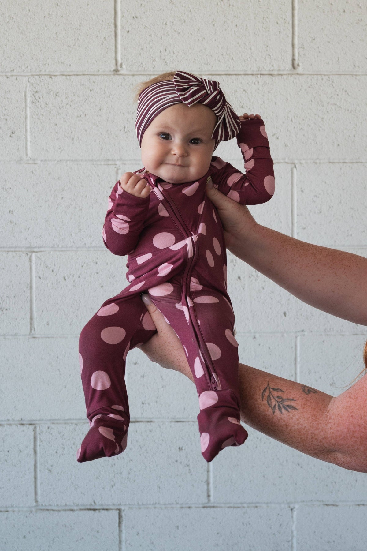 Pink dot zip pajamas with rollover hand cuffs on smaller sizes