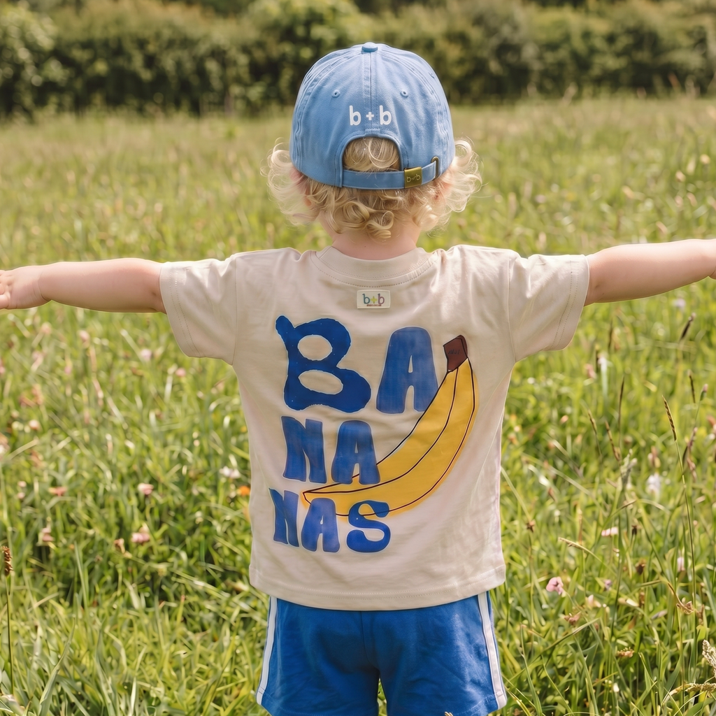 Small yellow banana graphic on the chest of the kids organic cotton tee
